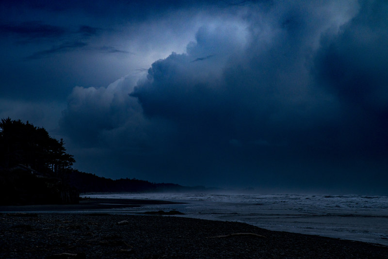 Dramatic illuminated storm cloud building over the dark Pacific Ocean at Kalaloch Beach